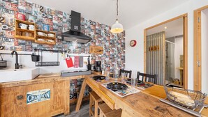 Une cuisine avec une table en bois, une cuisinière à gaz, un évier et un mur décoré de chiffres et de lettres.