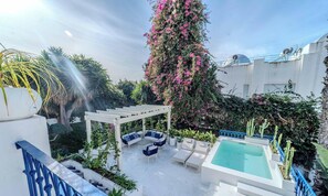 Ein Dachgarten mit Pool, Sitzgelegenheiten im Freien und einer Pergola.