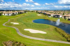 Ein Golfplatz mit Bunkern, einem Teich und einer Springbrunnen.