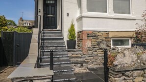 A house with a black front door, stone steps, and a stone wall. - 5 Thornbarrow Road (Windermere)