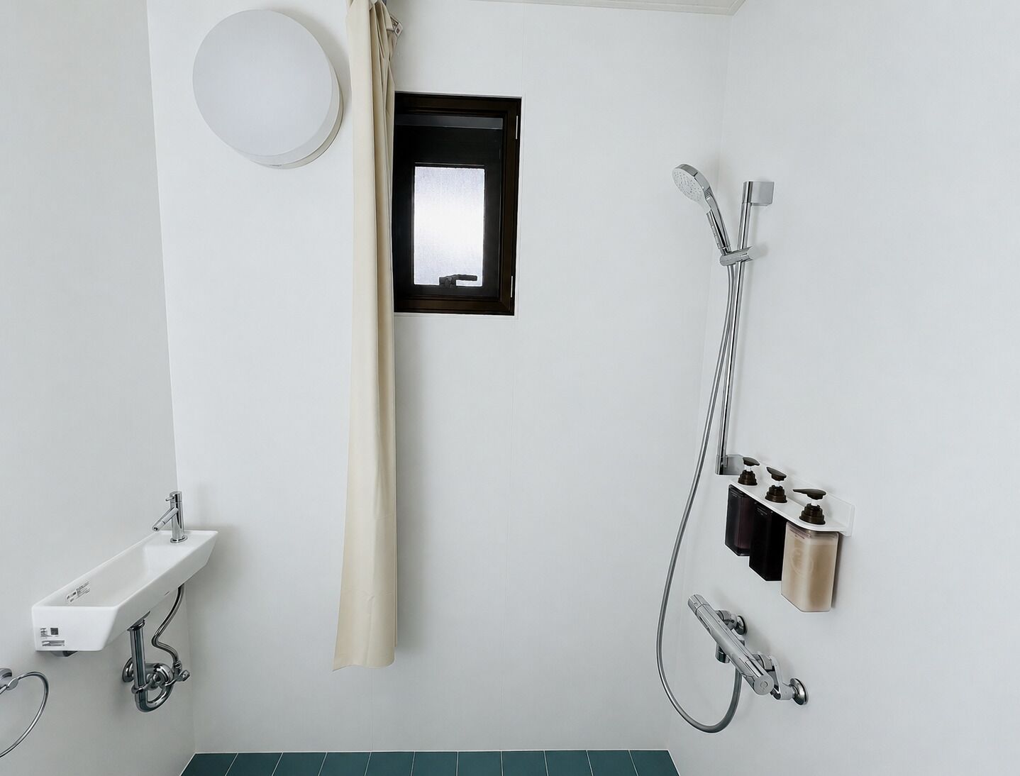 Ein Badezimmer mit Waschbecken, Dusche und kleinem Fenster.