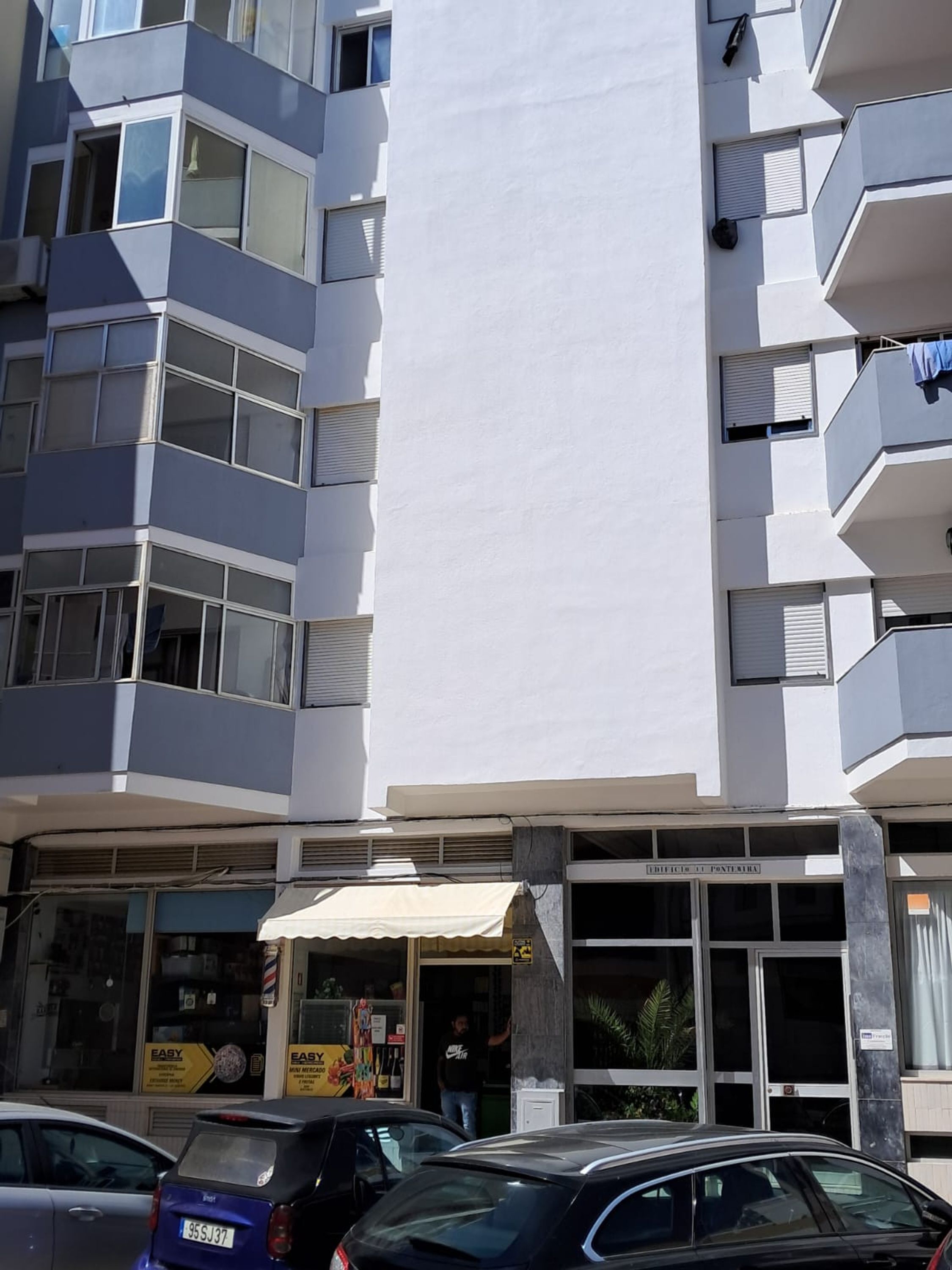 Un immeuble à plusieurs étages doté d’une façade plane, de grandes fenêtres et de balcons.