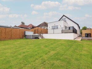 A modern house with a white exterior, a wooden fence, and a well-maintained lawn. - Bella Vista (Llandudno)