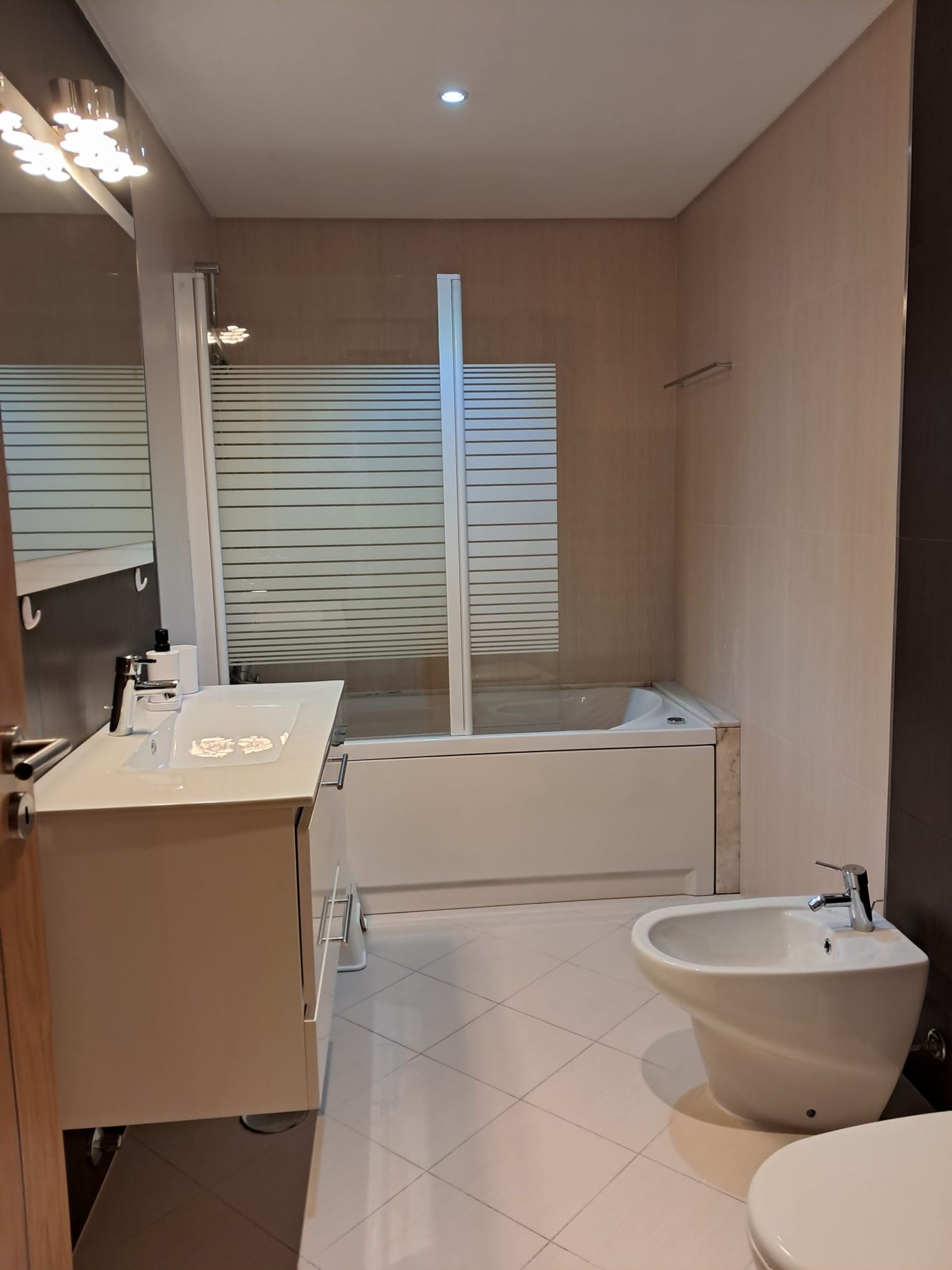 Un baño moderno con inodoro, bidé y lavamanos.