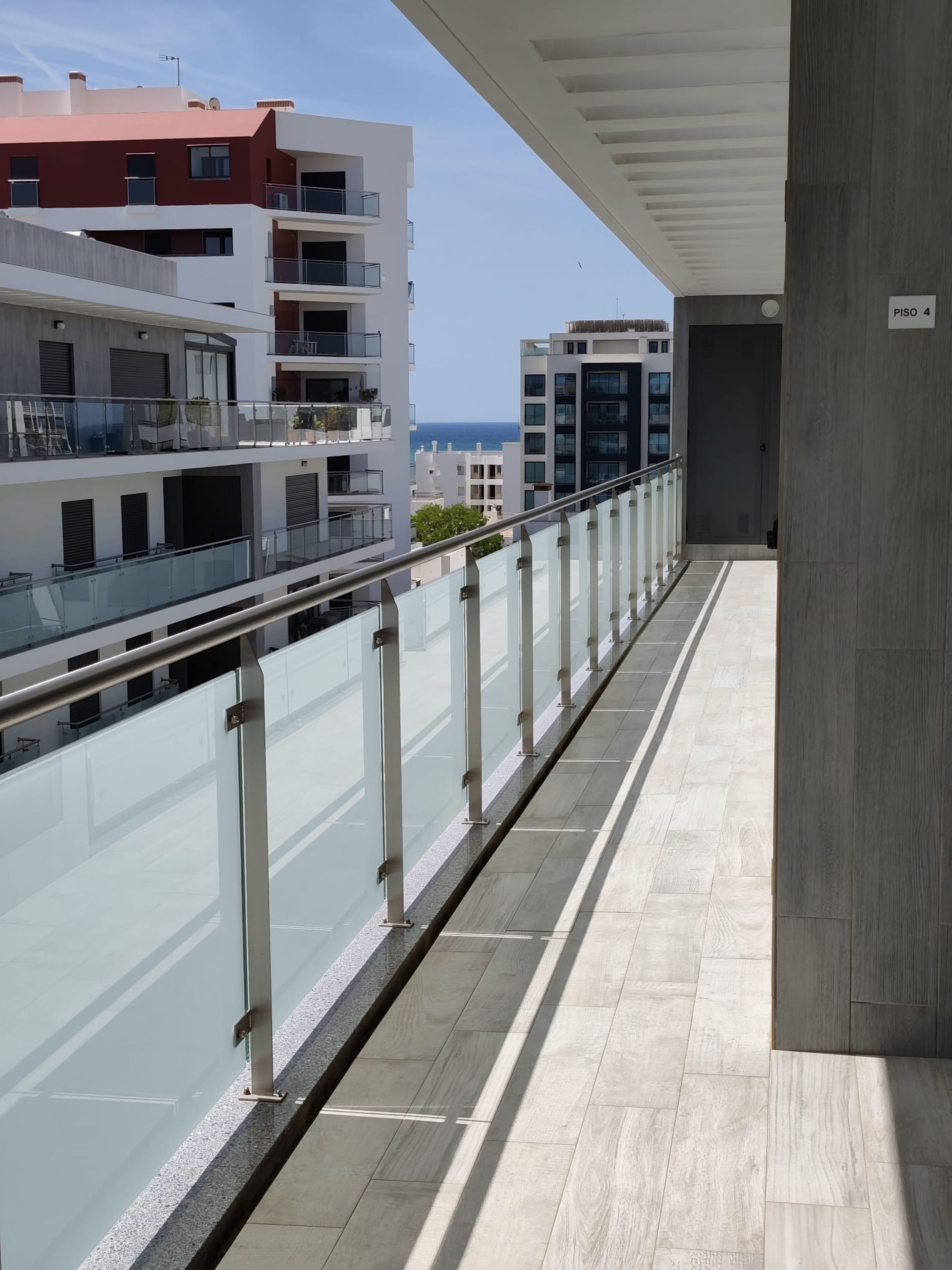 Un edificio moderno con balcón, vistas despejadas al mar y un letrero que indica 'PISO 4'.