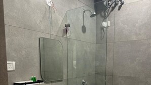Casa de banho moderna com cabine de duche em vidro, lavatório branco e sanita.