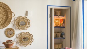 Una habitación con cama, cómoda, cesta y estante con cestas.