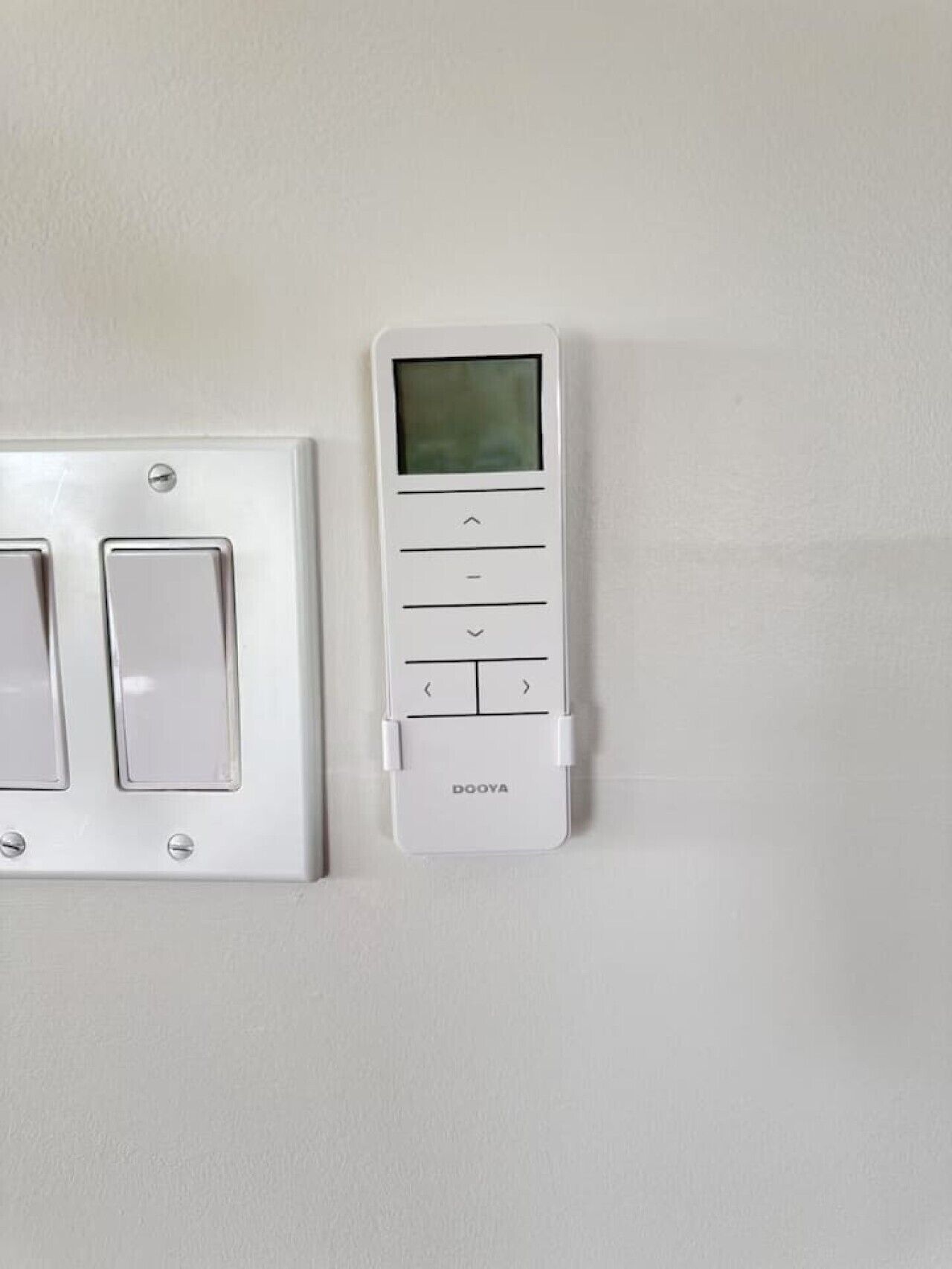 A wall-mounted thermostat and a light switch.