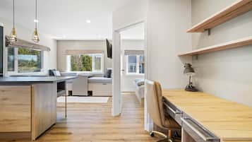 A modern kitchen with a wooden countertop, a built-in bench, and pendant lighting.