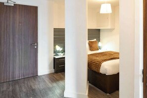 A bedroom with a bed, bedside table, lamp, and a view through an open door. - Host & Stay | Flat 3, 4 Leigh Street (Liverpool)
