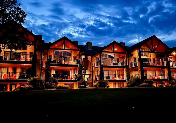A multi-story hotel with balconies, large windows, and a well-lit facade. - Condo 2 chambres - Ski in Ski out St Sau #206 (Saint-Sauveur)