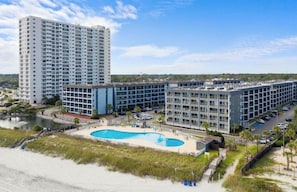 Ein Hotel mit Pool, mehreren Gebäuden und Blick auf den Strand.