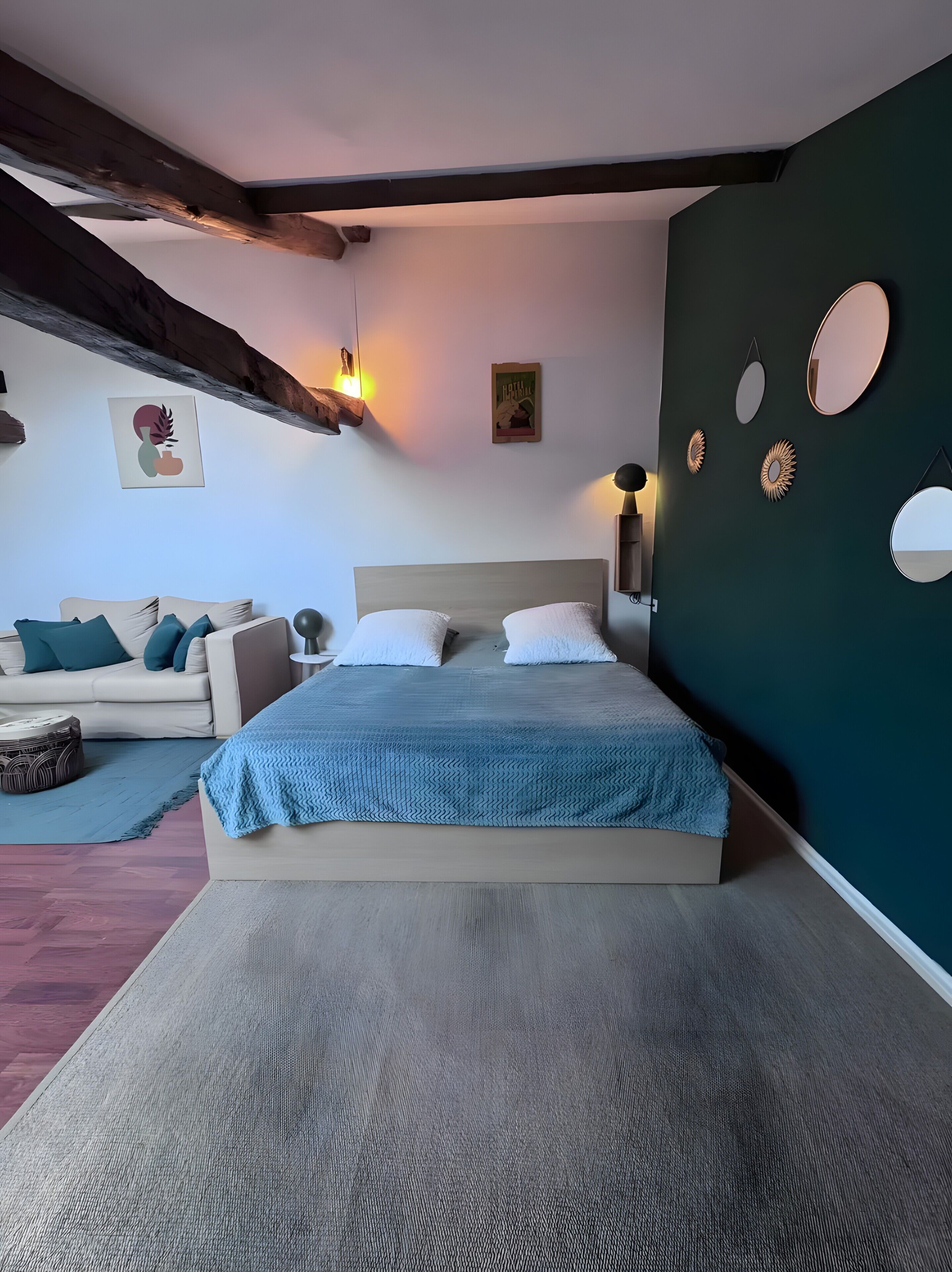 Une chambre à coucher comprenant un lit, un canapé, une table basse et des éléments décoratifs muraux.