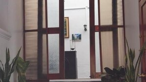 A set of wooden steps leading to a doorway with frosted glass panels and a wooden frame.