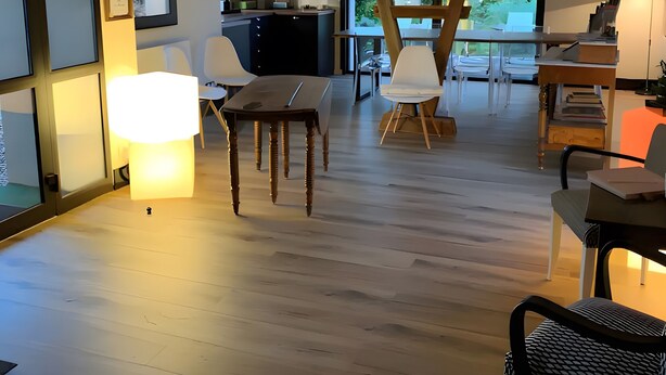 A spacious room with a wooden ceiling, a dining area with chairs, a table, and a kitchen area with a counter and chairs. - Standard Room “La Marine” (Senozan)