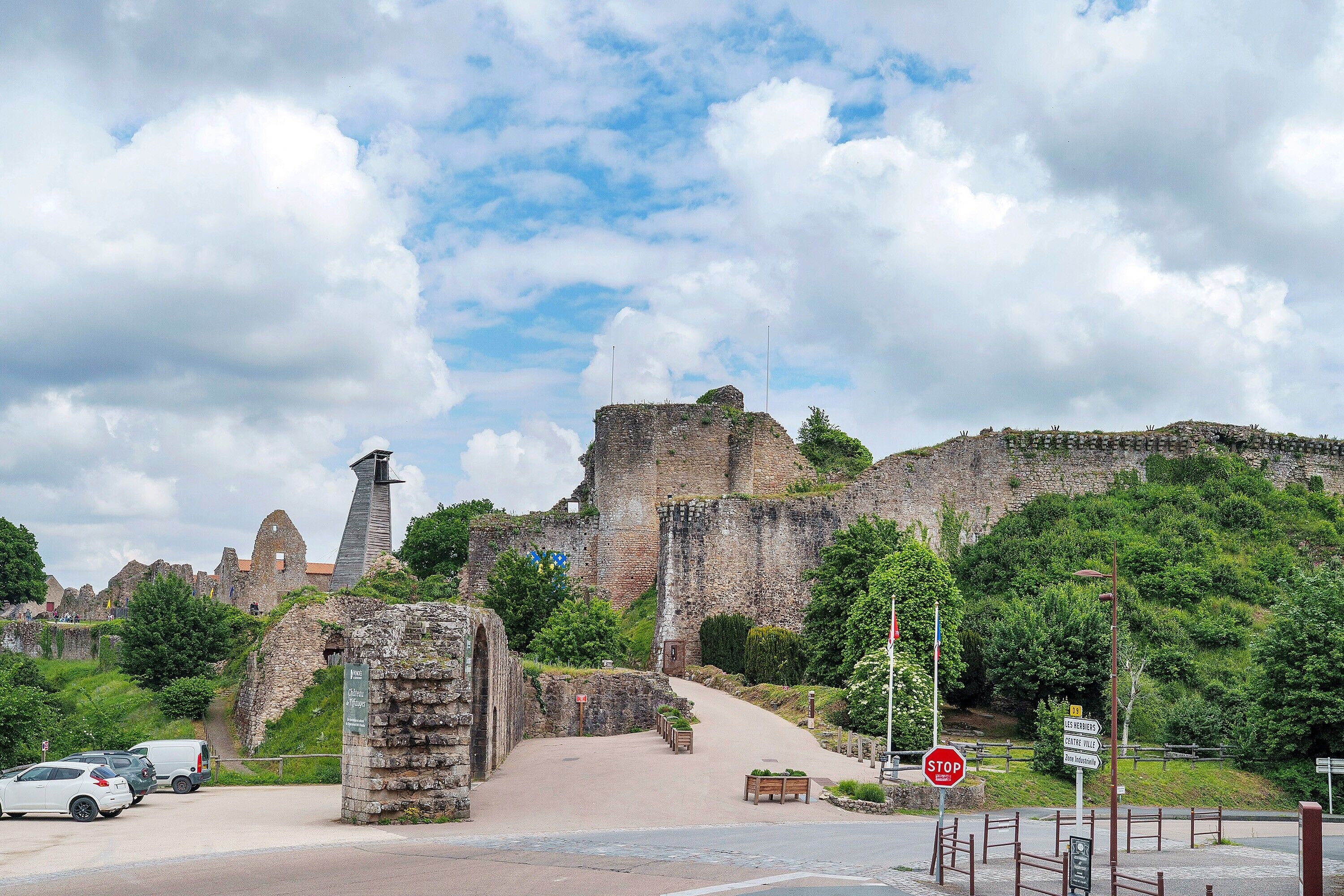 A historic site with ruins, a stop sign, and a paved pathway.