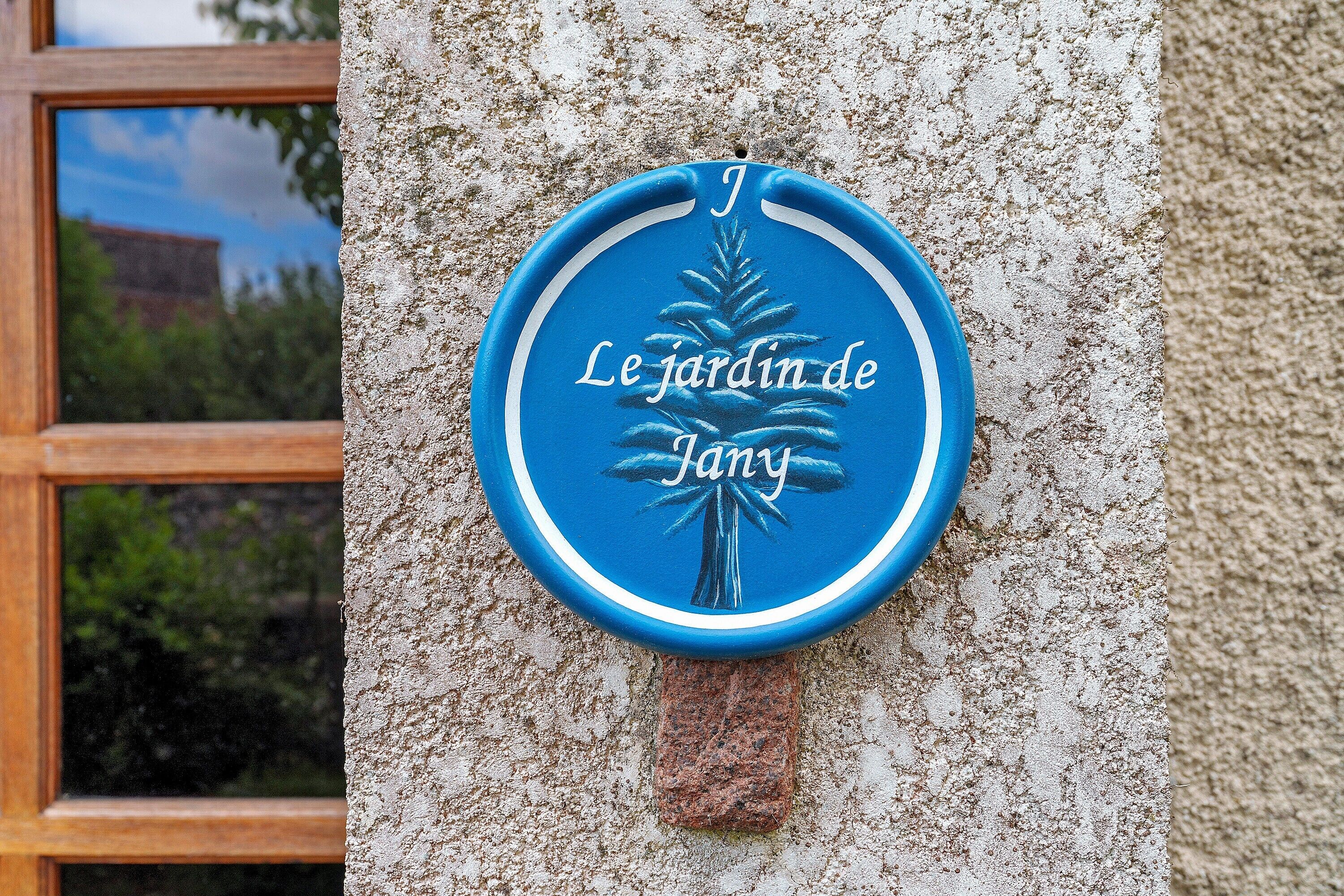 A blue plaque with a palm tree and text on a textured wall.