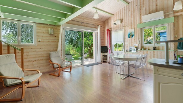 A modern interior with wooden walls, a dining area, and a kitchen.