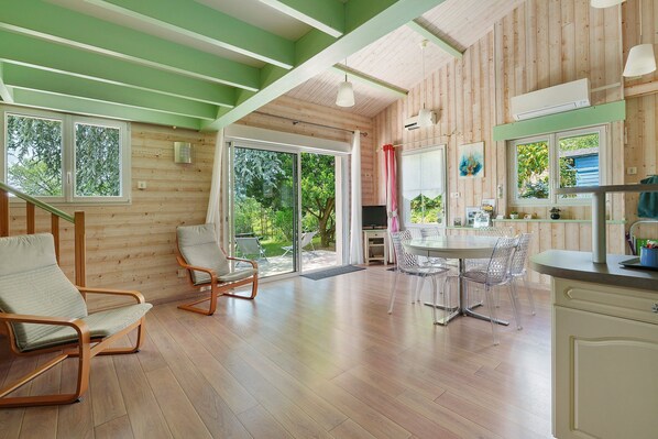 A modern interior with wooden walls, a dining area, and a kitchen.