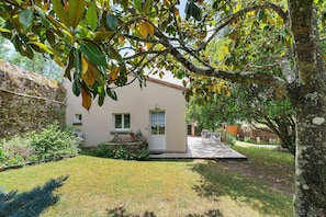 Uma casa com um pequeno jardim frontal, uma porta e uma janela.