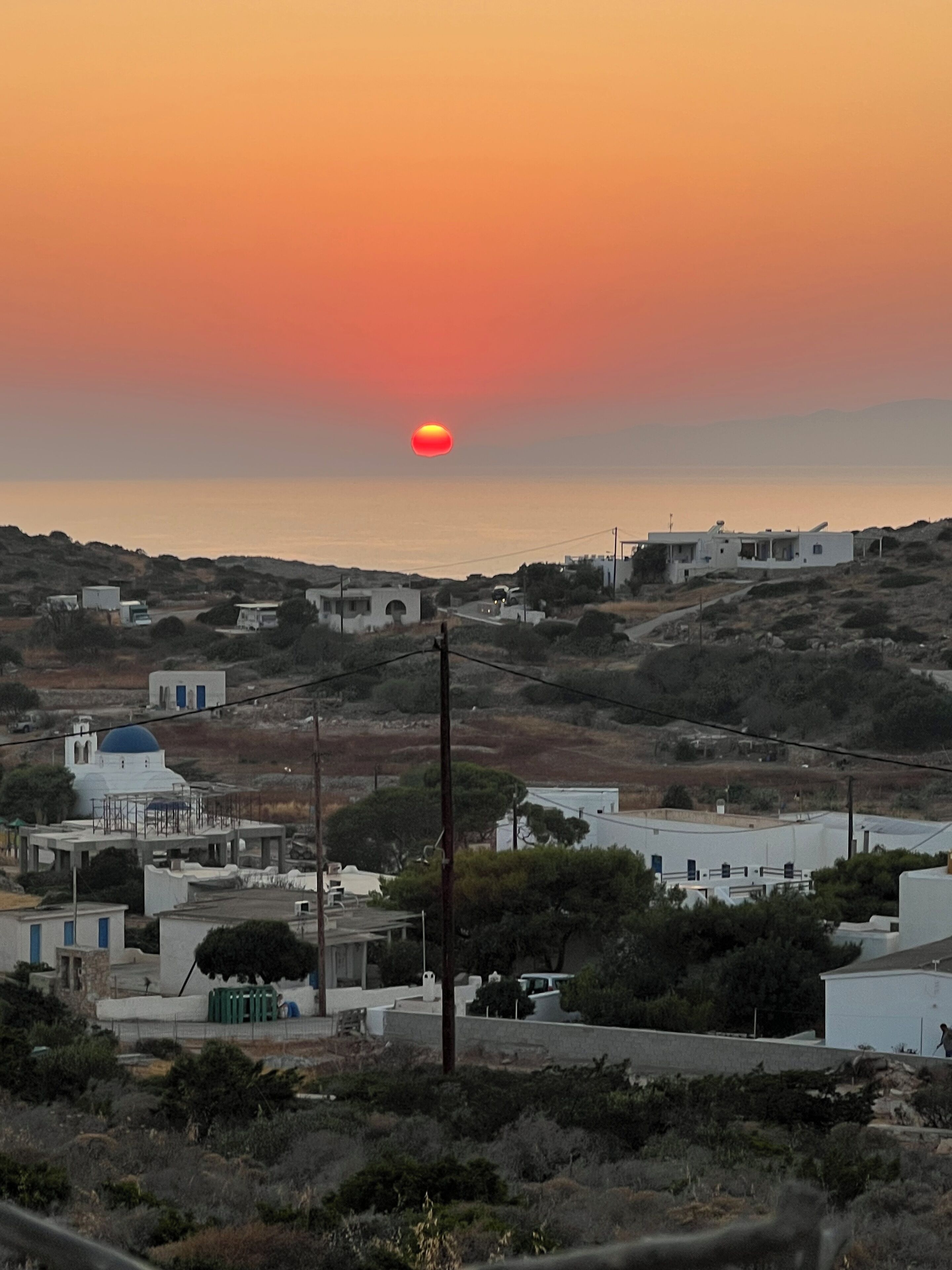 A coastal town with buildings, a road, and a clear sky.