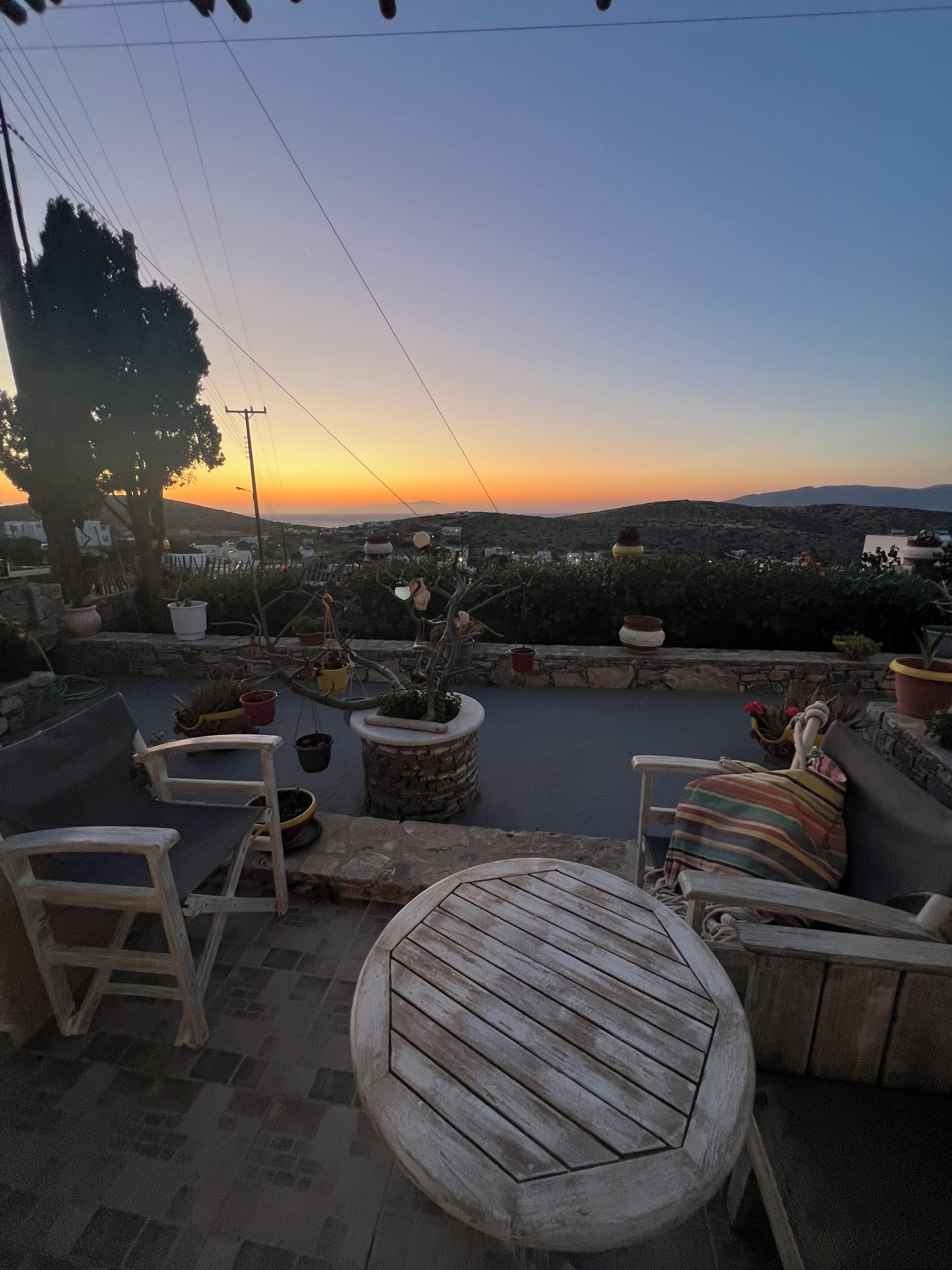 A patio with outdoor furniture, potted plants, and a view of the landscape.