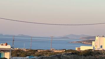 A coastal landscape with buildings, a clear sky, and a view of the sea.