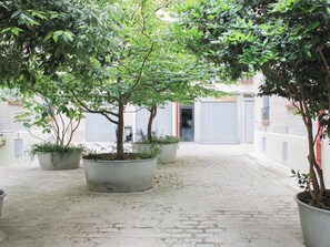 Ein Innenhof mit Blumentöpfen und einem Pflasterweg.