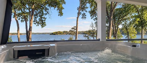 Un jacuzzi con vistas a un lago y árboles.