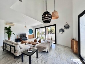 Ein modernes Wohnzimmer mit Sofa, Couchtisch und Fernseher.