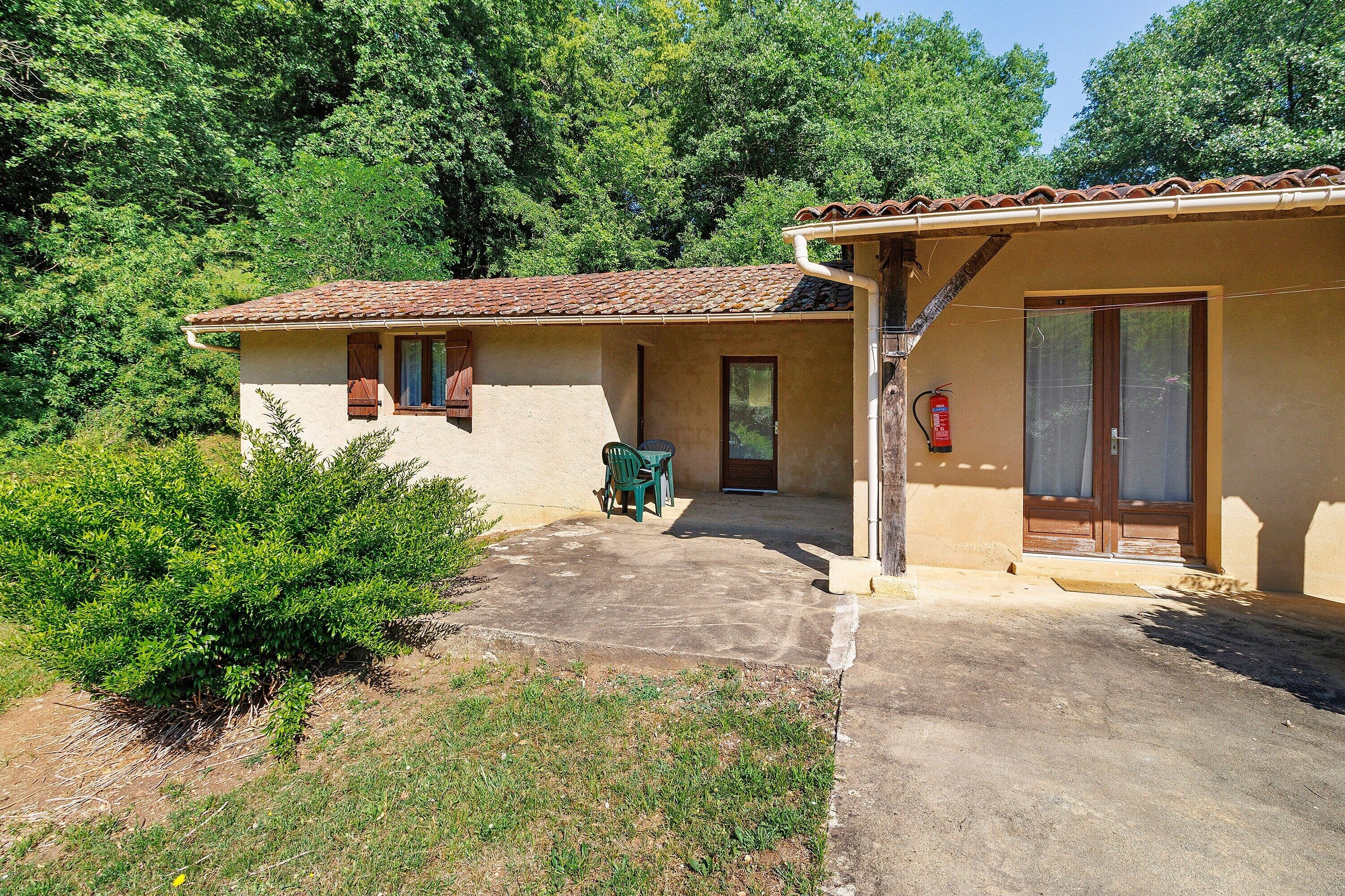 A two-story building with a tiled roof, a door, and a window.