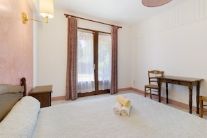 Ein Schlafzimmer mit Bett, Schreibtisch, Stuhl und Nachttisch.