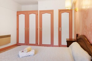 Une chambre à coucher avec un lit, une table de chevet et trois portes.