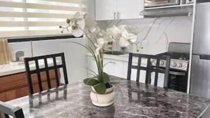 A modern kitchen with white cabinets, a microwave, and a dining table with chairs. - 1 bedroom and 1 bathroom apartment in Monte Vista, Sosúa (Sosúa)