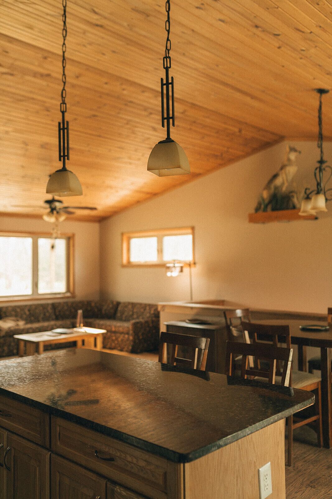Une cuisine avec des meubles en bois, un îlot central et des luminaires suspendus.
