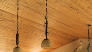 Una cocina con armarios de madera, una isla central e iluminación colgante.