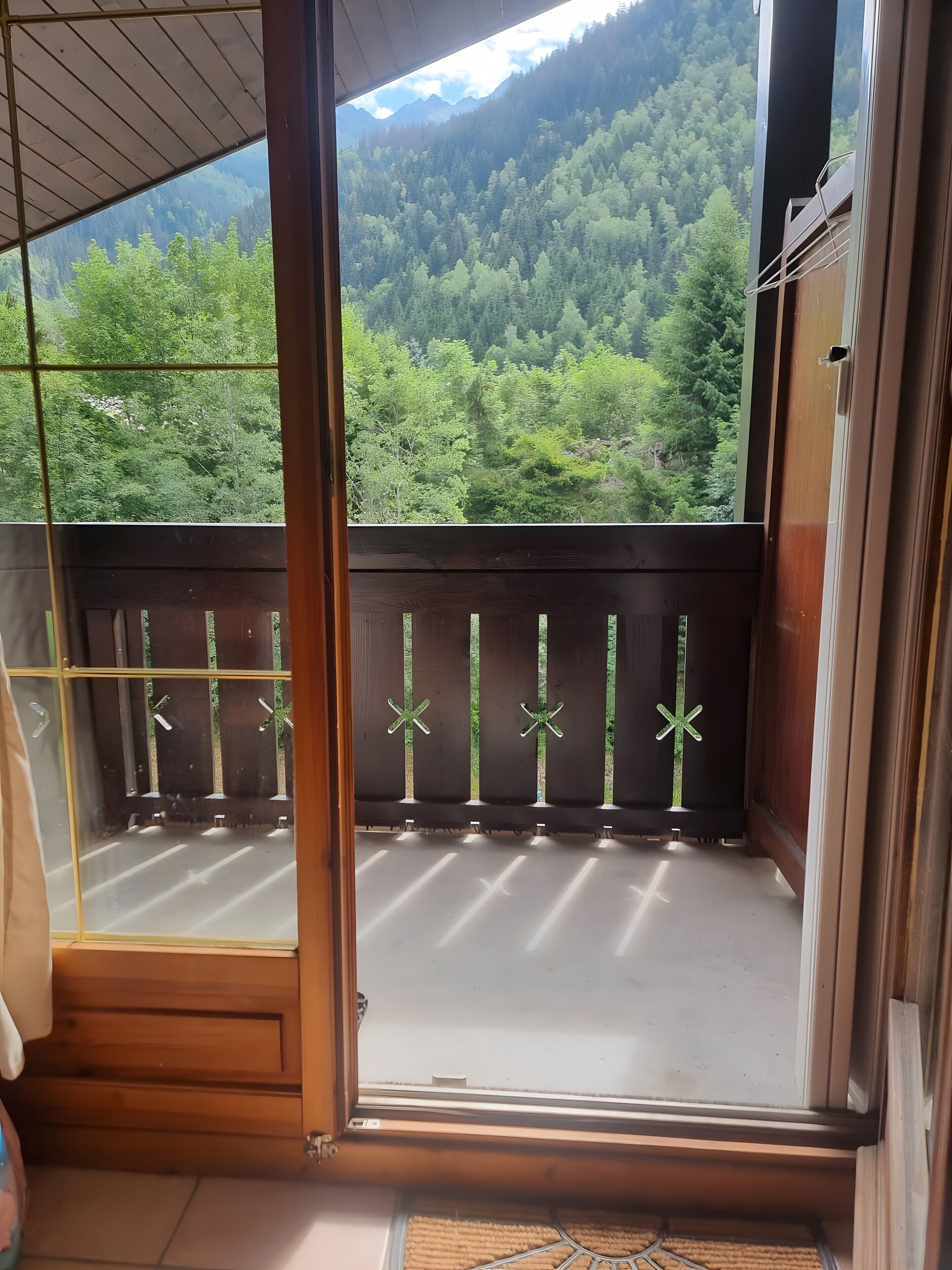 Een balkon met uitzicht op een bebost berglandschap.