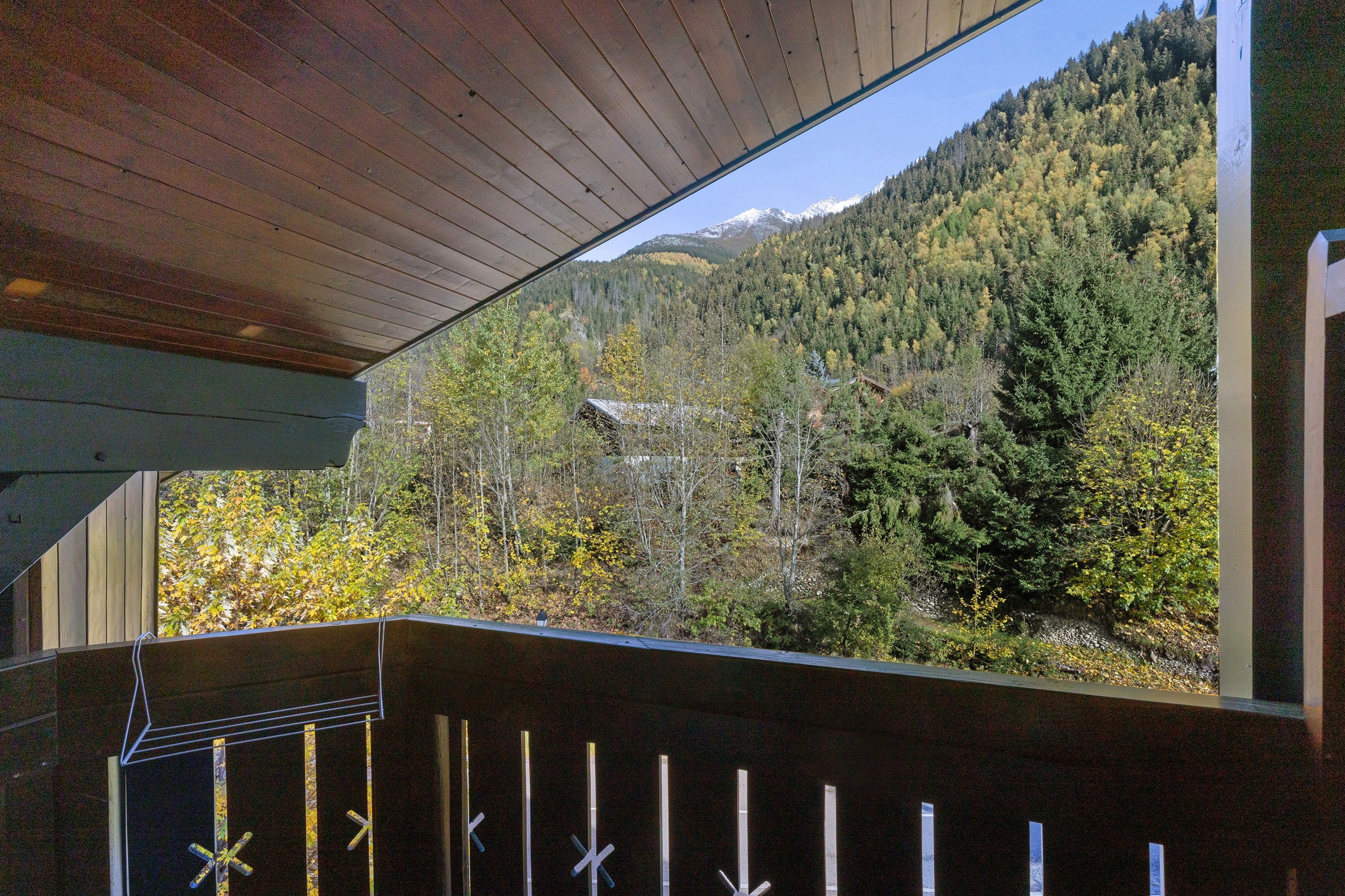 A wooden deck with a view of a forested mountain.