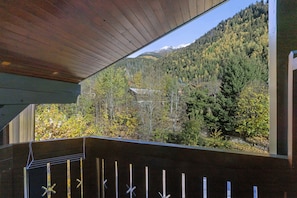 A wooden deck with a view of a forested mountain. - Apartment 'Les Contamines Montjoie' with Mountain View, Private Terrace and Balcony (Les Contamines-Montjoie)