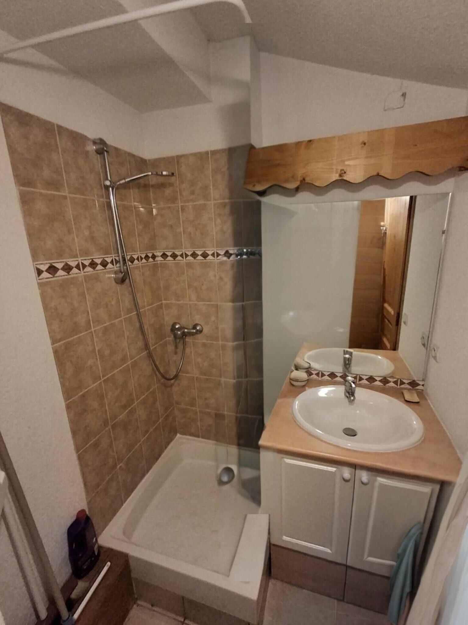A bathroom with a shower, a sink, and a mirror.