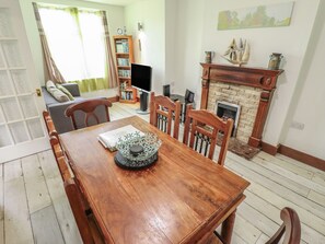 Ein Esszimmer mit Holztisch, Stühlen, Kamin und Bücherregal.