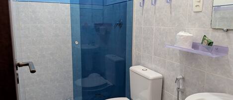 Un baño con inodoro, lavamanos y cabina de ducha.