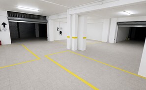 A clean, empty parking garage with marked parking spaces and a fire extinguisher.