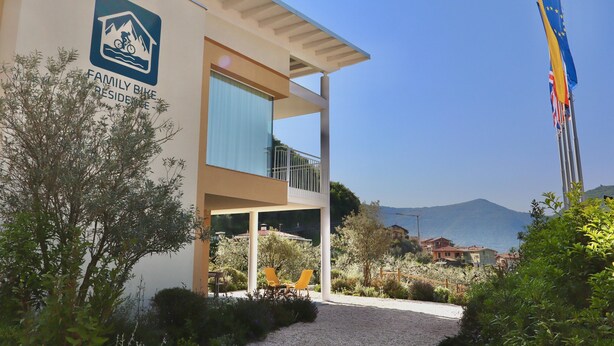 A building with a balcony, a flag, and a view of the sea. - In a Residence, Air-conditioned, With Terrace (Marone)