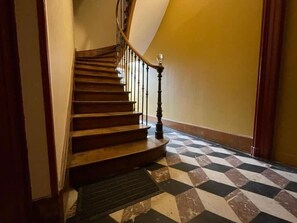A staircase with wooden steps and a black balustrade, leading to a landing with a checkered floor pattern. - Queen Bed • Fully Equipped Quiet Apartment • Amiens Centre • 5-min Walk to Station • Parking on Site (Amiens)