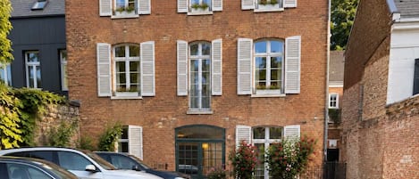 A brick building with multiple windows and a gated entrance.