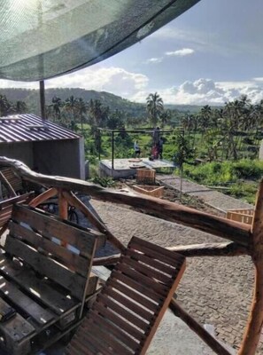 A wooden deck with a view of a rural landscape, including palm trees and a clear sky. - Suite with Pool and Nature View (Achada Fazenda)