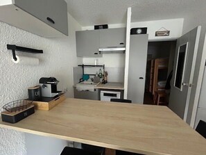 A compact kitchen with a wooden countertop, a sink, and a stove. - South-facing terrace studio in resort center (Enchastrayes)