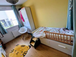 A child's bedroom with a bed, a chair, a wardrobe, and a radiator. - Lyon Center Apartment with private garden & garage (Lyon)