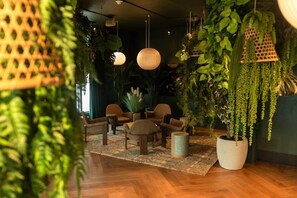 A room with wooden flooring, a patterned rug, wicker furniture, hanging plants, and pendant lights. - Cloud 23 Miami | 1 BR + Den Luxe Suite (Miami)